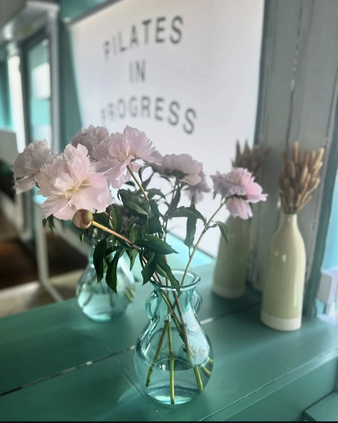 Studio details with pink flowers and pilates signage